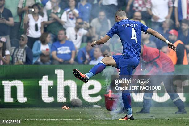 Croatia's midfielder Ivan Perisic kicks a flare thrown by supporters during the Euro 2016 group D football match between Czech Republic and Croatia...