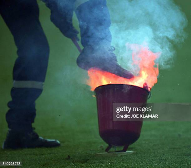 Fire fighter extinguish flares lobed onto the pitch during the Euro 2016 group D football match between Czech Republic and Croatia at the...