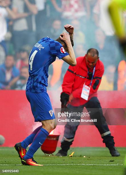 Marcelo Brozovic of Croatia reacts to fire works being thrown onto the pitch during the UEFA EURO 2016 Group D match between Czech Republic and...