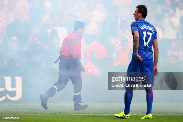 Mario Mandzukic of Croatia looks on as flares are thrown onto the picth during the UEFA EURO 2016 Group D match between Czech Republic and Croatia at...