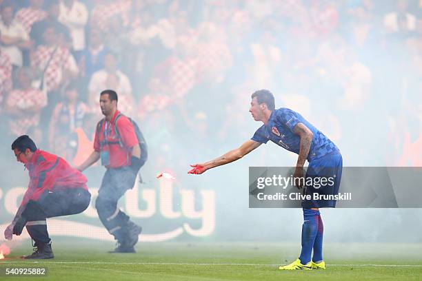 Mario Mandzukic of Croatia reacts as flares are thrown onto the picth during the UEFA EURO 2016 Group D match between Czech Republic and Croatia at...