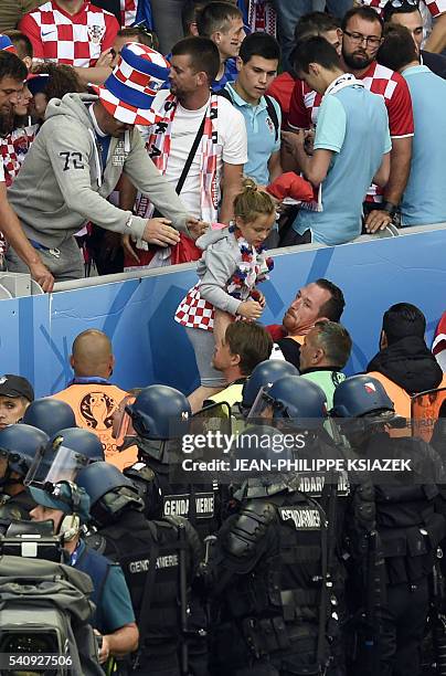 Croatia fans helps a child from the stands as flares are lobed onto the pitch and a fight breaks out during the Euro 2016 group D football match...