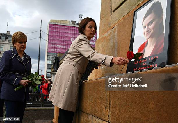 First Minister of Scotland Nicola Sturgeon and Leader of Scottish Labour party Kezia Dugdale place roses near the photograph of Labour MP Jo Cox...