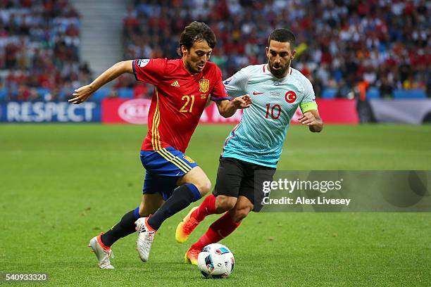 David Silva of Spain is chased down by Arda Turan of Turkey during the UEFA EURO 2016 Group D match between Spain and Turkey at Allianz Riviera...