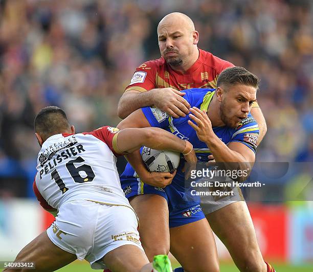 Matty Russell of Warrington Wolves is tackled by Eloi Pelissier and Glenn Stewart of Catalan Dragons during the First Utility Super League Round 19...