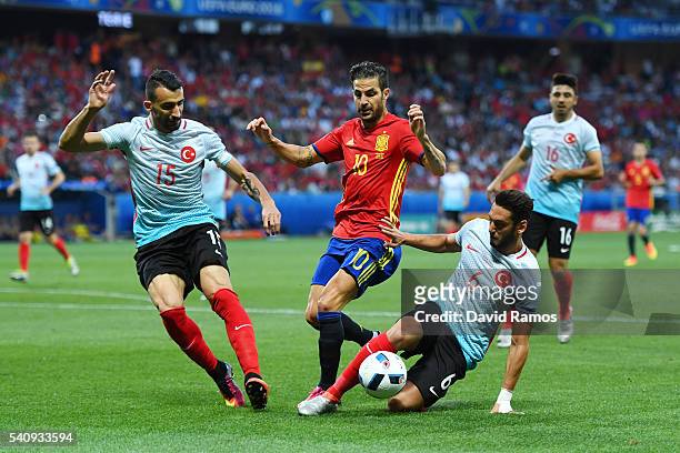 Cesc Febregas of Spain is tackled from each angle by Mehmet Topal and Hakan Calhanoglu of Turkey during the UEFA EURO 2016 Group D match between...