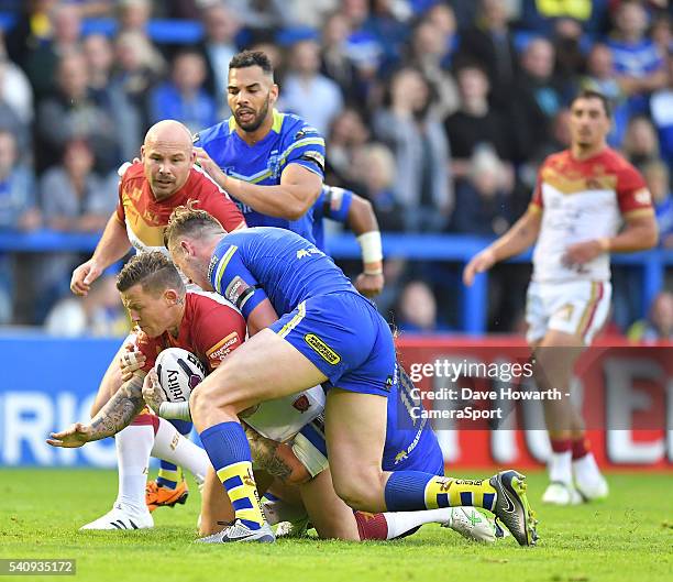 Todd Carney of Catalan Dragons is tackled during the First Utility Super League Round 19 match between Warrington Wolves and Catalans Dragons at the...