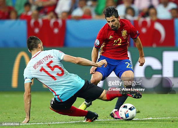 Mehmet Topal of Turkey goes to ground whilst tackling Nolito of Spain during the UEFA EURO 2016 Group D match between Spain and Turkey at Allianz...