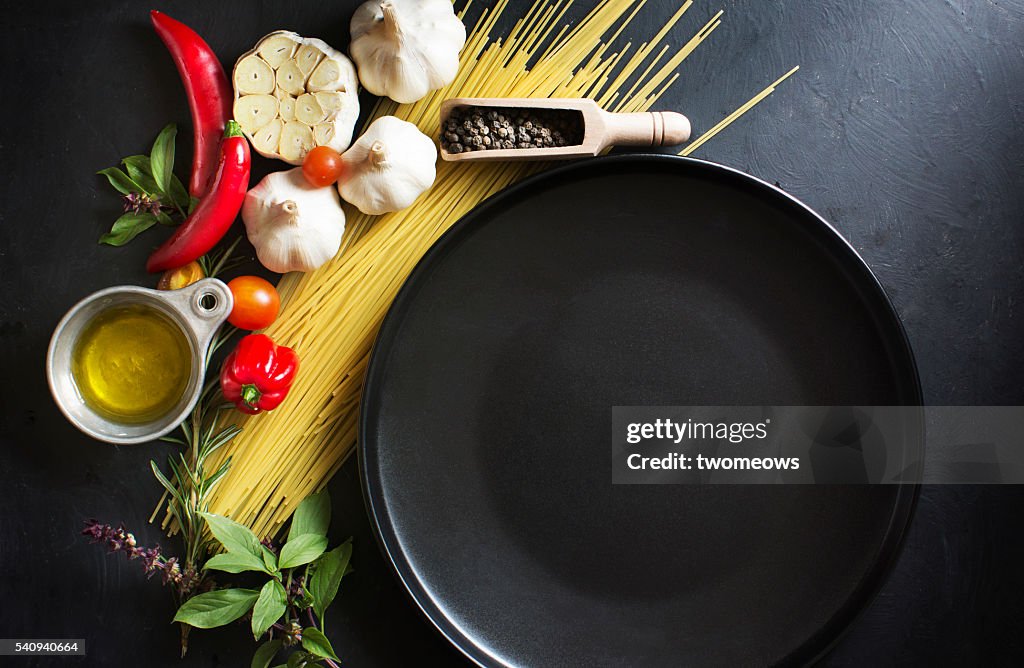 Italian food, spaghetti recipe ingredient on black texture background.