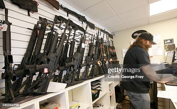 Row of guns many that are AR-15's line the wall as owner of Ready Gunman, Willy Ludlow, works on paperwork on June 17, 2016 in Springville, Utah....