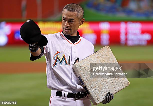 Ichiro Suzuki of the Miami Marlins is presented with the base celebrating his 4,257th hit between Japan and MLB during a game against the Colorado...