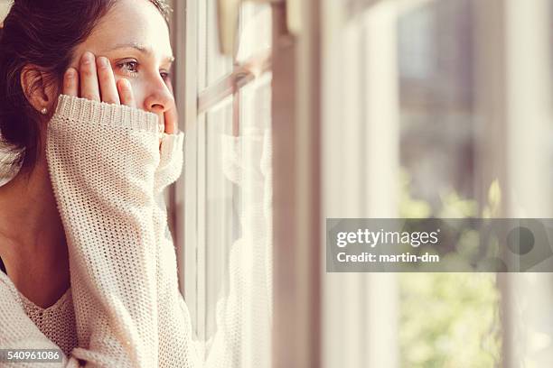 girl looking through the window - despair stock pictures, royalty-free photos & images