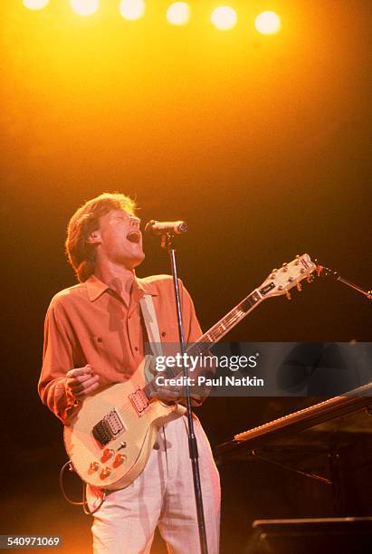 British musician Steve Winwood plays guitar as he performs onstage, Chicago, Illinois, July 9, 1988.