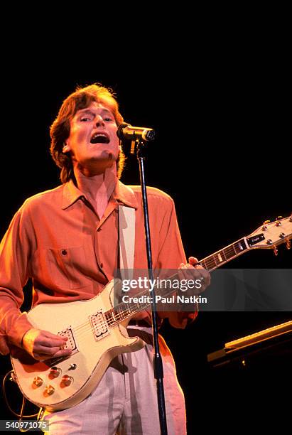 British musician Steve Winwood plays guitar as he performs onstage, Chicago, Illinois, July 9, 1988.