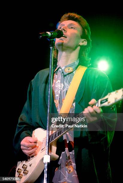 British musician Steve Winwood plays guitar as he performs onstage, Chicago, Illinois, August 25, 1986.