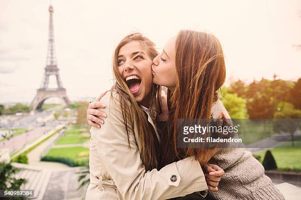 friends in paris - friends kissing cheeks stockfoto's en -beelden