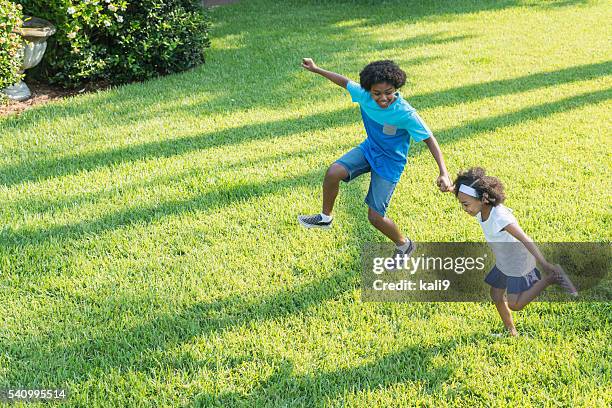 mixed race brother and sister playing in park - happy family grass stock pictures, royalty-free photos & images