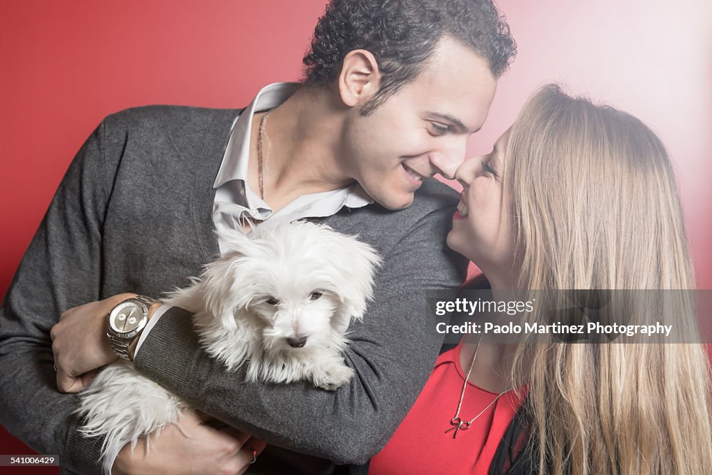 Couple in love embracing their puppy dog