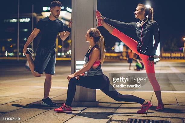 stretch your muscles - woman capturing city night stockfoto's en -beelden