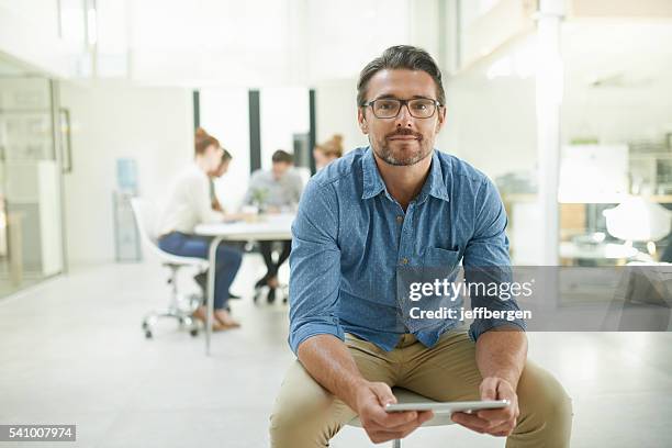 wir halten unser büro so papierlos wie möglich - mann sitzt auf stuhl stock-fotos und bilder