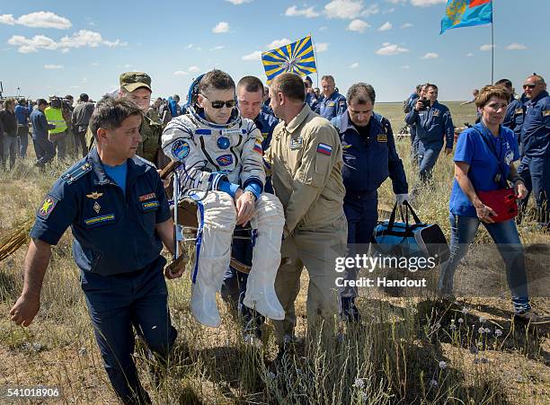 Yuri Malenchenko of Roscosmos is carried to a medical tent after he and Tim Kopra of NASA and Tim Peake of the European Space Agency landed in their...