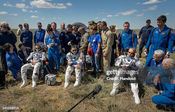 Tim Peake of the European Space Agency, Yuri Malenchenko of Roscosmos and Tim Kopra of NASA sit in chairs outside the Soyuz TMA-19M spacecraft just...