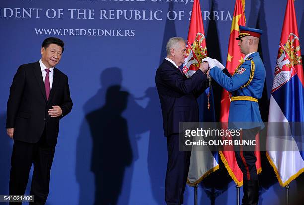 Serbian President Tomislav Nikolic prepares to award China's President Xi Jinping with the Grand Collar of the Order of the Republic of Serbia after...