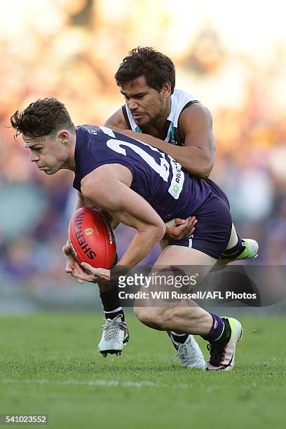 Lachie Neale of the Dockers is tackled by Jake Neade of the Power during the round 13 AFL match between the Fremantle Dockers and the Port Adelaide...