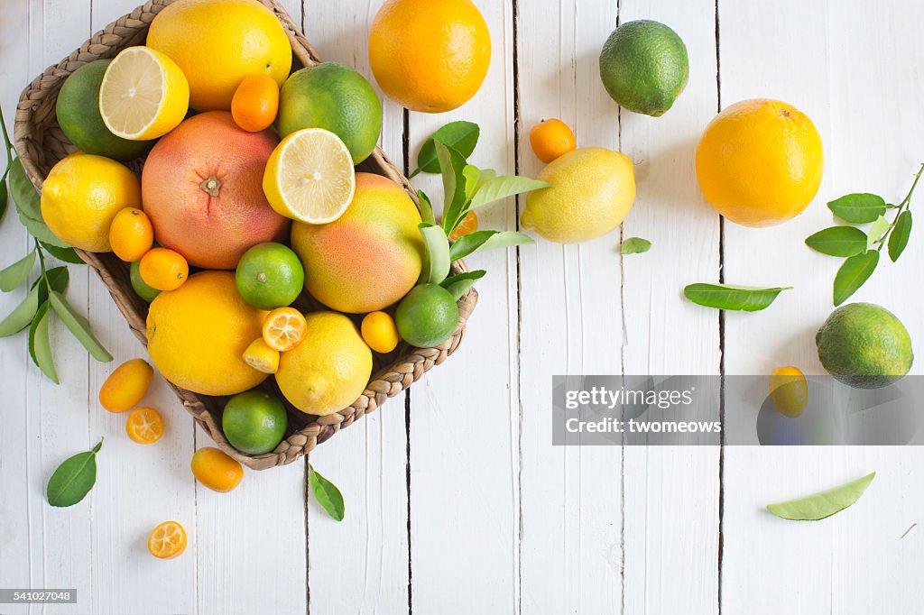 Citrus fruits family on rustic white wooden background. Horizontal view. Text space images.