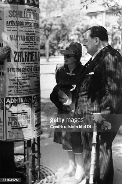 Heinrich George*09.10.1893-+Schauspieler DBerliner Gastspiel in Budapest:mit Ehefrau Berta Drews vor einer Litfaßsäule mit der Ankündigung der...