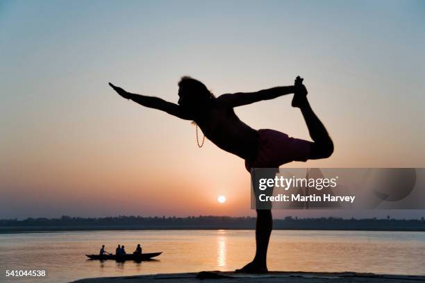 yogi holding pose near ganges river - ganges stockfoto's en -beelden