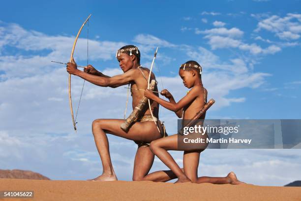 san father teaching son traditional hunting techniques - boog pijl en boog stockfoto's en -beelden