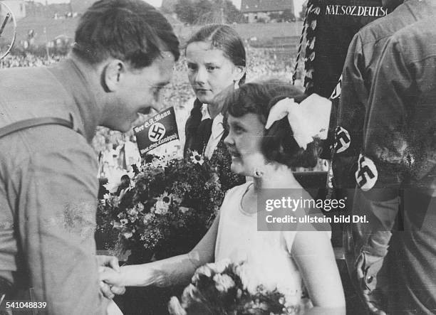 Politiker, NSDAP, D- wird am Rande einer Veranstaltung vonzwei Mädchen mit Blumen begrüsst- veröffentlicht