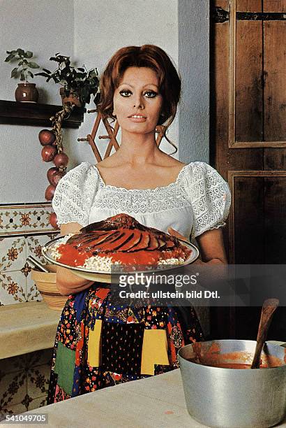 Loren, Sophia *- Schauspielerin, Italien- in der Kueche ihres New Yorker Hauses: haelt einen Teller mit einem Auberginengericht- 1972