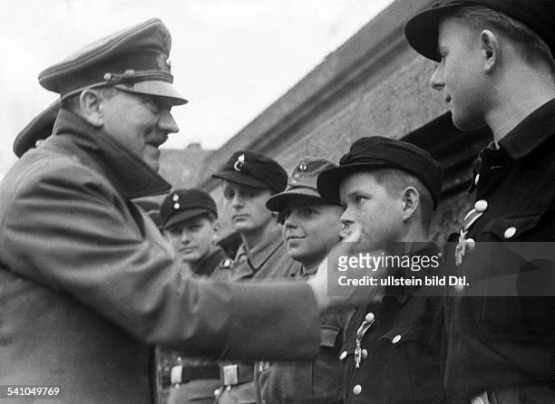Adolf Hitler in the garden of the chancellery in Berlin talking to members of the 'Hitler-Jugend' , who are being decorated with the medal 'Eisernes...