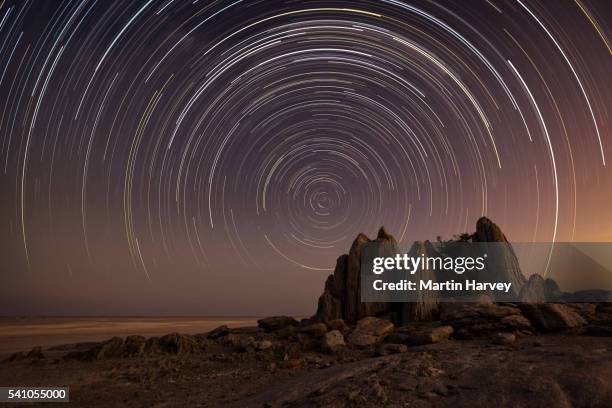 star trail over the dry granite rock outcrop on kubu island, makgadikgadi pans, botswana - star trails stock pictures, royalty-free photos & images