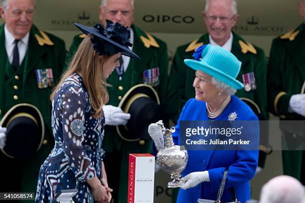Princess Beatrice presents Queen Elizabeth II with the trophy, after her horse Dartmouth won The Hardwick Stakes, on day 5 of Royal Ascot at Ascot...