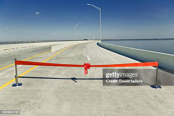 red ribbon across highway bridge over escambia bay - finishing line stock pictures, royalty-free photos & images