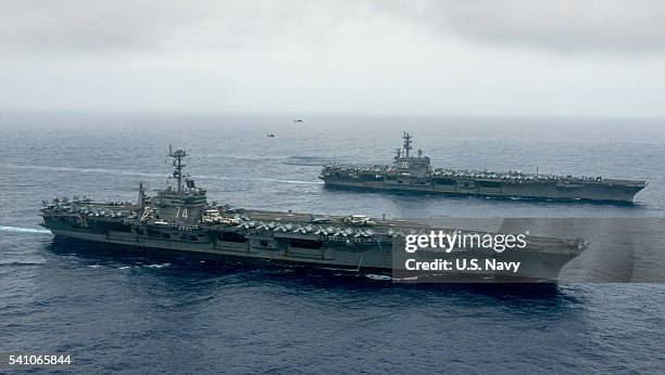 In this handout provided by the U.S. Navy, The Nimitz-class aircraft carriers USS John C. Stennis , center, and USS Ronald Reagan conduct dual...