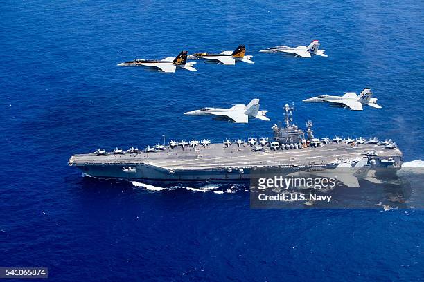 In this handout provided by the U.S. Navy, a combined formation of aircraft from Carrier Air Wing 5 and Carrier Air Wing 9 pass in formation above...
