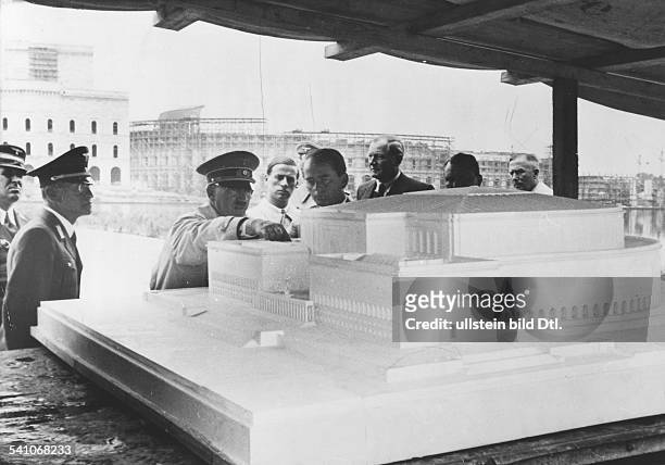 Politiker, NSDAP, D- auf dem Gelände des Reichsparteitags inNürnberg vor dem Modell der neuenKongresshalle ; imHintergrund der begonnene Bau...