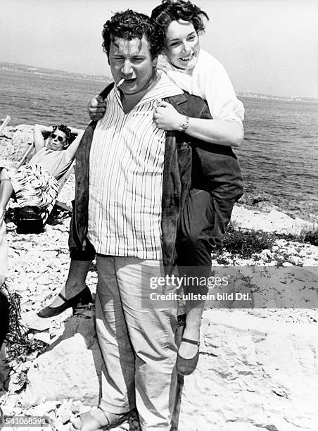 Ustinov, Peter *-+Schauspieler, Schriftsteller, Regisseur, Maler, GB- mit seiner Frau Suzanne Cloutier an der Riviera, er traegt sie huckepack- 1955