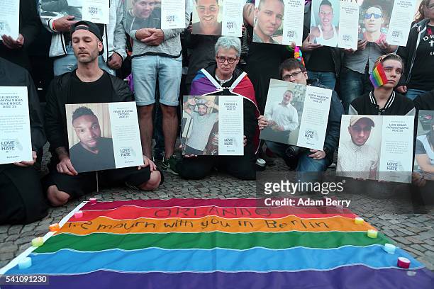 Mourners hold photographs of victims of a shooting at a gay nightclub in Orlando, Florida nearly a week earlier, during a vigil in front of the...