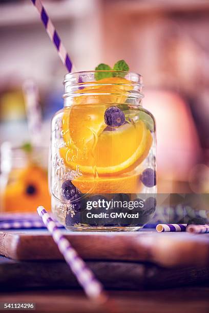 con abundante agua fresca de arándanos y naranjas - agua infusionada fotografías e imágenes de stock