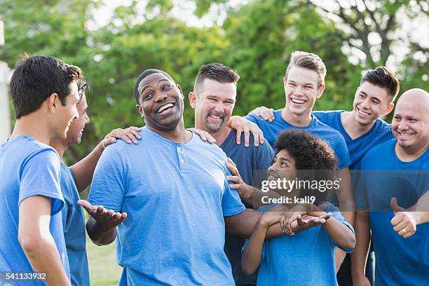 black man in group getting pat on back - reputation stock pictures, royalty-free photos & images