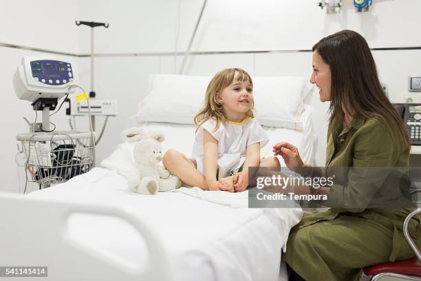 mother taking care of her daughter in the hospital - child hospital bed stockfoto's en -beelden