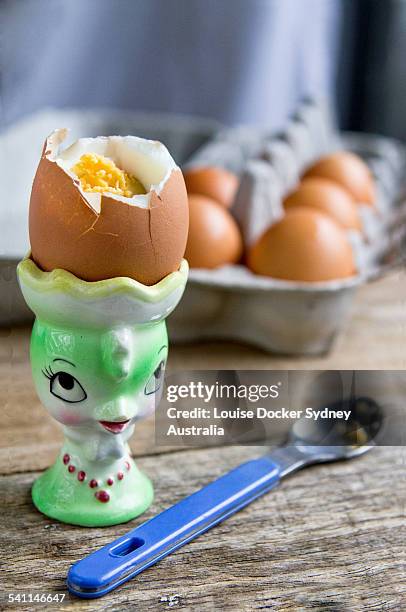 boiled egg in kitsch egg cup with spoon - egg cups stock pictures, royalty-free photos & images