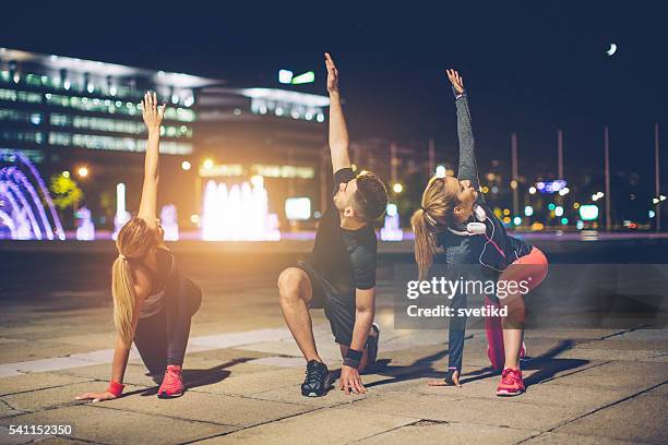 distendi i muscoli - woman capturing city night foto e immagini stock