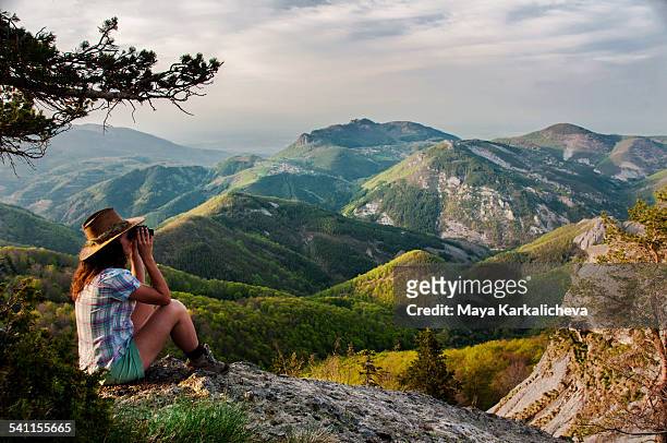 young woman looking  with binoculars in a mountain - bulgarije stockfoto's en -beelden