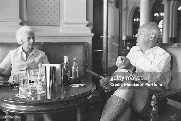 Russian-American writer Vladimir Nabokov sitting and talking in a room of Montreux Palace Hotel, where he is staying. Next to him is his wife Vera...